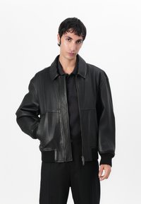 Black leather jacket with a collared neck, zip closure, and ribbed cuffs. Features side pockets and a smooth texture, with no visible patterns.