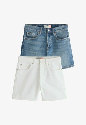 Blå denimshorts lagdelt bag hvide denimshorts, begge med knapper foran, bæltestropper og lommer.