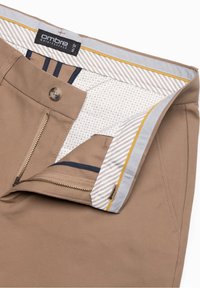 Beżowe spodnie z częściowo rozpiętym zamkiem błyskawicznym, zapięciem na guzik oraz wewnętrznym paskiem w paski z czarną metką marki „ombre”.