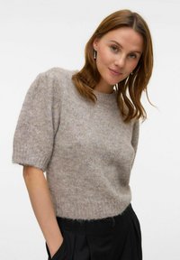 Maglione corto, a maniche corte, di colore marrone chiaro, con una vestibilità rilassata, realizzato in filato morbido. Texture a coste sui polsini e sull'orlo, con un motivo minimale.