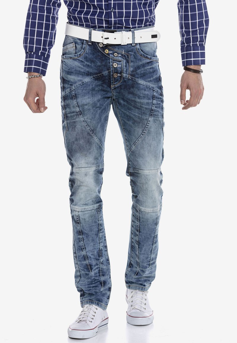 Lichtblauwe denim jeans met een slim fit, vervaagde gebieden, zichtbare stiksels en designaccenten op de zakken. Gecombineerd met witte sneakers.