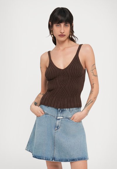 Καφέ πλεκτό τοπ χωρίς μανίκια με βαθύ V λαιμόκοψη και υφή σε μοτίβο, σε συνδυασμό με ανοιχτό μπλε τζιν φούστα γραμμή A με τσέπες.