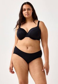 Ensemble de lingerie noire comprenant un soutien-gorge à bonnets moulés avec bretelles larges et un bas bikini noir assorti. Tissu lisse, design simple, sans ornements.
