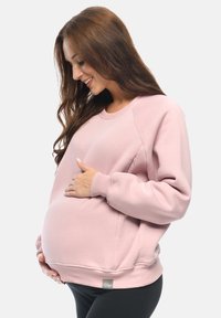 Felpa per maternità rosa con maniche lunghe, scollo rotondo e vestibilità comoda. Presenta polsini e orlo a costine, con un dettaglio di tasca laterale.