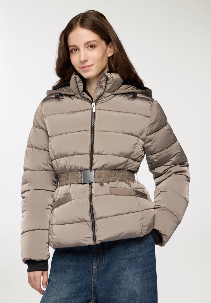 Giacca beige imbottita con cappuccio, dotata di zip frontale, vita con cintura e tasche laterali. Texture liscia con motivi a trapunta orizzontali.