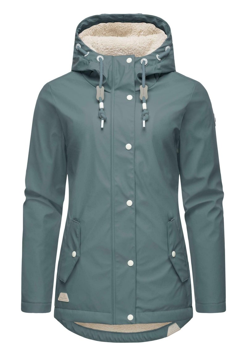Giacca impermeabile color teal con cappuccio foderato, bottoni a pressione frontali, due tasche laterali e un orlo posteriore più lungo. Interno foderato in morbido fleece.