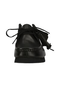 Mustat nahkakengät pyöreällä varpaalla, litteillä kangasnauhoilla ja teksturoidulla pohjalla. Varpaantilan ympärillä on koristeommel.