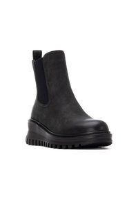 Botas negras hasta el tobillo con una parte superior de aspecto de cuero suave, paneles laterales elásticos, puntera redondeada y suelas gruesas texturizadas para mayor tracción.