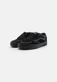 Svarte fløyels-sneakers med hvit søm og klassisk design. Har solid svart gummisåle og snøring foran.