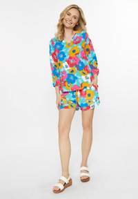 Blomstret outfit med en multifarvet, langærmet top og matchende shorts, lavet af letvægtigt stof. Inkluderer sidelommer.