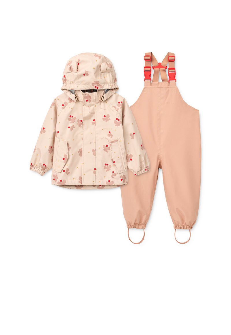 Αδιάβροχο μπεζ μπουφάν με ροζ λουλουδάτο σχέδιο και ρυθμιζόμενο κουκούλα, συνδυασμένο με αντίστοιχες ροζ σαλοπέτες με ελαστικά τελειώματα και ιμάντες.
