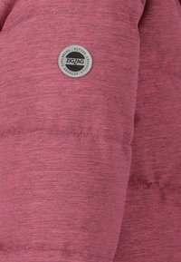 Pink puffjakke med et tekstureret stof, der har zigzag-detaljer og et cirkulært logo patch mærket "ZIGZAG" til en aktiv livsstil.