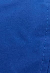 Κοντινή λήψη απαλού μπλε υφάσματος με ορατές κάθετες ραφές στη δεξιά πλευρά.