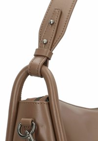 Borsa a mano in pelle marrone con una superficie liscia, dotata di una maniglia resistente, una tracolla regolabile e accessori in metallo vicino al punto di attacco.