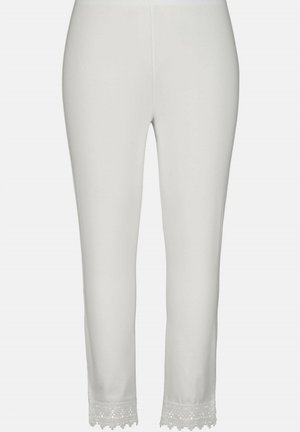 White leggings made of soft fabric. Features a lace trim at the hem with a scalloped design. Elastic waistband for comfort.