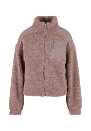 Švelniai rudos spalvos sherpa fliso striukė su pilnu priekinio užtrauktuko uždarymu, aukštu apykakliu, elastingais rankogaliais ir užtrauktuku užsegama krūtinės kišenė su lygiu audinio skydeliu.