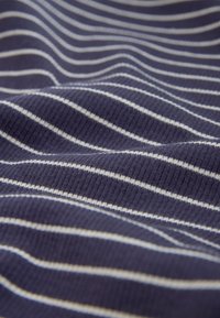 Navy ribbed fabric with horizontal white stripes, featuring a soft texture and uniform line pattern, creating a subtle wave effect.