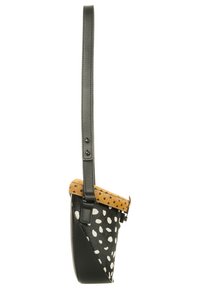 Small black and white polka dot handbag with a textured yellow top, featuring a smooth black base and a long, adjustable strap.