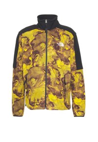 Giacca in pile con motivo tie-dye giallo e marrone, spalle nere, zip anteriore completa, tasche con zip e logo The North Face sul petto.
