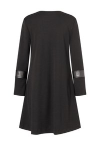 Schwarzes Kleid mit ausgestellter Form, langen Ärmeln und glänzenden schwarzen Akzenten an den Bündchen. Hergestellt aus einem weichen, strukturierten Stoff.