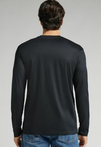 Zwart T-shirt met lange mouwen, met een zachte textuur en ronde halslijn, in een standaard pasvorm zonder zichtbare patronen.