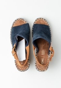 Námořnické semišové sandály s hnědým koženým páskem, nabízející otevřenou patu, tkanou jutovou podrážku a plochou, polstrovanou stélku.