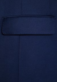 Granatowy teksturowany materiał z prostokątną klapą kieszeni, charakteryzujący się prostym, czystym designem. Materiał wydaje się być wytrzymały i tkany.