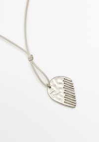 Ciondolo d'argento a forma di pettine su un cordino grigio chiaro, con una superficie testurizzata e nove denti verticali; nodo regolabile per la lunghezza.