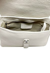 Borsa a tracolla in pelle bianca con texture a ciottoli, chiusura a scatto magnetica e rivestimento beige all'interno. Presenta una tasca con zip per una migliore organizzazione.