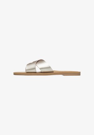 Metallic rose gold slide sandal with two crossed straps, flat tan sole, smooth texture, and minimalistic design.