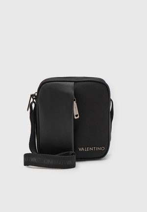 Sac bandoulière noir Valentino avec poche avant zippée, anse réglable siglée et logo Valentino sur le bas devant.