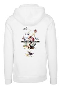 Sudadera blanca con un diseño floral y mariposas. El texto dice "DÉJATE TIEMPO", acentuado con una banda negra. Tejido suave.