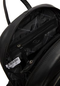 Interno di uno zaino in pelle nera che mostra diversi scomparti con zip, texture liscia e una fodera con il marchio "The Chesterfield Brand."