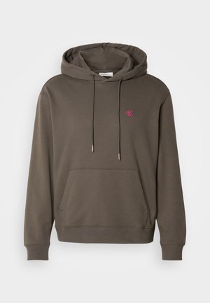 Harmaa huppari, jossa on etutasku, nyöri ja pieni vaaleanpunainen logo rinnassa. Pehmeää kangasta sekä ribatut hihansuut ja helma.