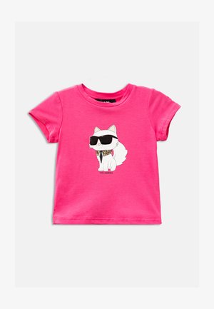 T-shirt di cotone rosa con una grafica di un gatto bianco che indossa occhiali da sole neri, con perline dorate e un design a cravatta sul collo.