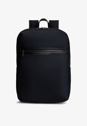 Black rectangular backpack with padded shoulder straps, front zippered pocket, and subtle logo detail on pocket trim.