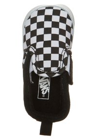 Zapatilla Vans de tela de cuadros en blanco y negro con interior negro y una tira en la parte trasera, vista desde arriba.