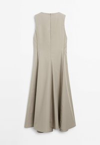 Robe beige sans manches avec ourlet évasé et fermeture éclair au dos, présentée sur un fond blanc uni.