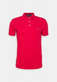Červené polo tričko z bavlny s klasickým límečkem, třemi knoflíky, krátkými rukávy a malým modrým logem na levé straně hrudníku.
