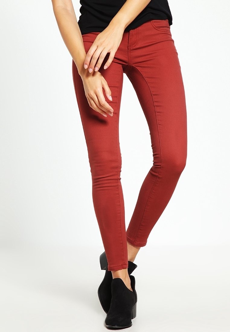 Czerwone, dopasowane dżinsy z denimu, o gładkiej teksturze i slim fit, zestawione z czarnymi botkami za kostkę.