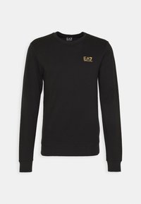 Sudadera negra de cuello redondo, de mangas largas, fabricada en algodón. Presenta un logo dorado de EA7 en el lado izquierdo del pecho y puños y dobladillo acanalados.