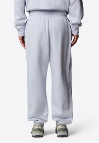 Ljusgrå sweatpants i mjukt tyg, med resårmidja och tapered ben, med diskret logotyp nära nederkanten.
