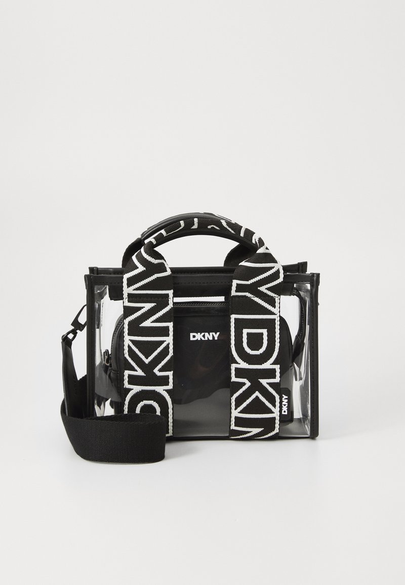 Průhledná vinylová kabelka s černými akcenty a výrazným bílým logem DKNY. Obsahuje široké, vzorované popruhy a černou vnitřní kapsu.