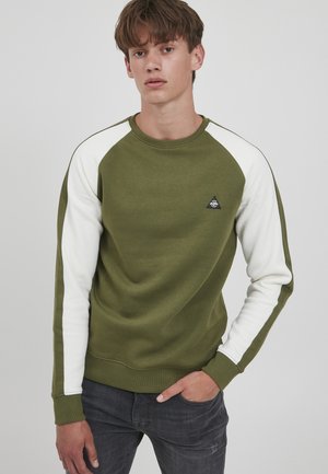 Olive green sweatshirt with white raglan sleeves, round neckline, and a small triangular logo. The fabric appears soft with a smooth texture.
