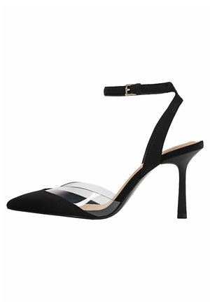 Zapato de tacón con punta negra en forma de punta, tira trasera slingback de acrílico transparente, correa ajustable en el tobillo y material de ante texturizado. Cuenta con un tacón de aguja.