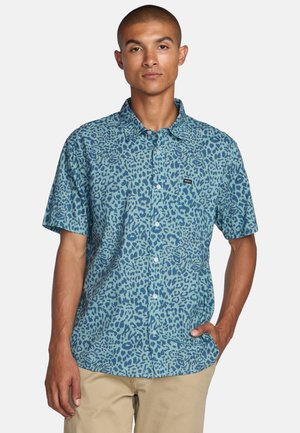 Short-sleeve button-up shirt in blue with a leopard print pattern. Made of lightweight fabric, featuring a collar and pocket with a logo.