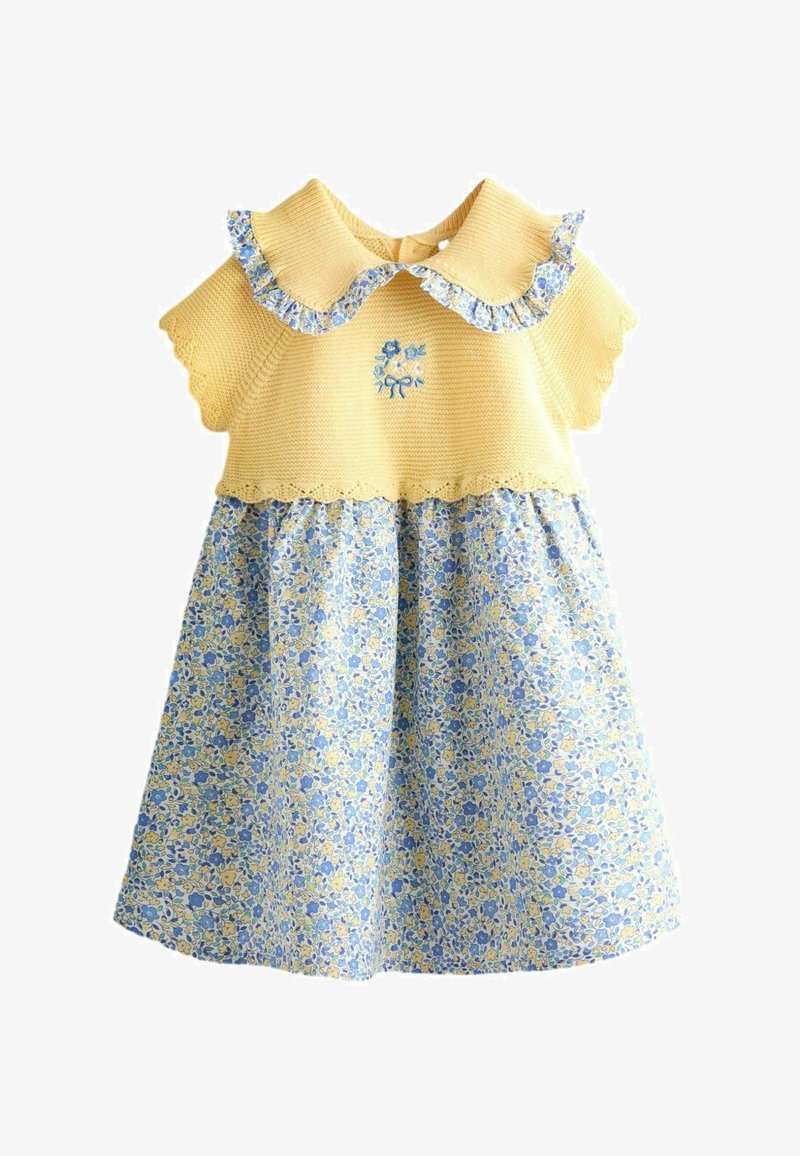 Vestido de bebé de punto amarillo con cuello festoneado y mangas cortas, con falda floral azul y amarilla y detalle de flor bordada en el pecho.