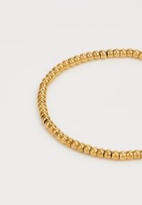 Goldfarbener Perlenarmband mit runden, glatten Metallperlen in einheitlicher Größe, die ein durchgängiges kreisförmiges Design bilden.