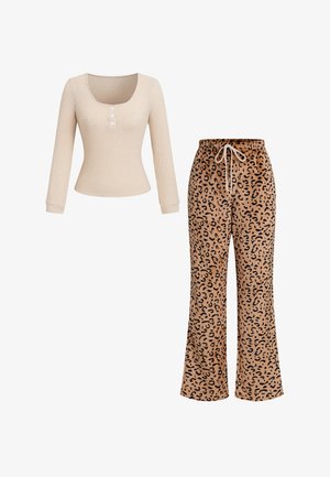 Beige geribd langarmshirt met drie knopen, gecombineerd met bruine, wijd uitlopende broek met luipaardprint en trekkoord in de taille.