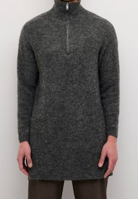 Grauer Pullover mit Reißverschluss am Hals, einem strukturierten Strickdesign, langen Ärmeln und einem lässigen Schnitt, aus weichem, flauschigem Material gefertigt.